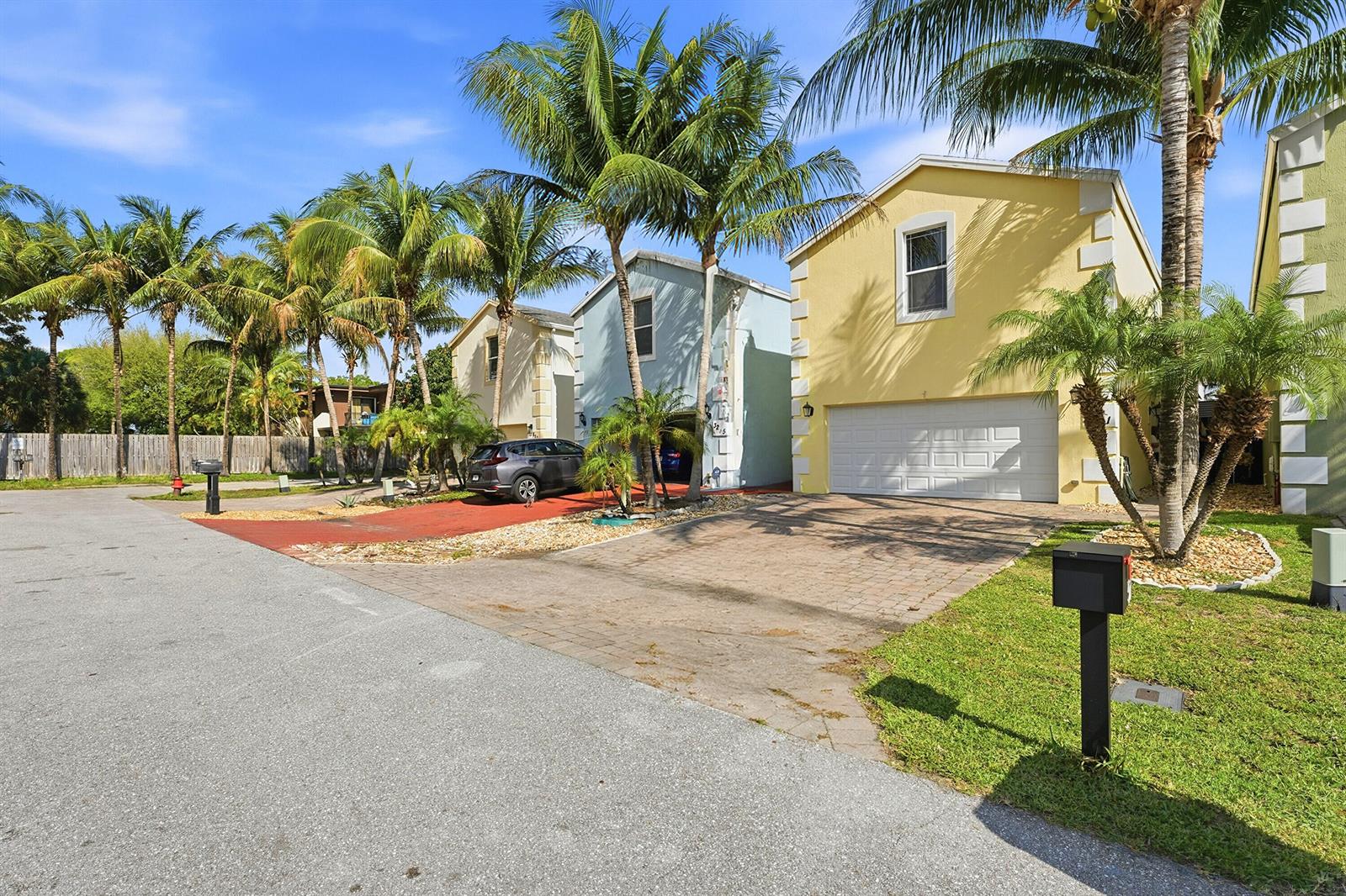 A street view of three suburban houses with palm trees and paved driveways — 3221 Johns Place, Palm Springs FL 33461, PALM SPRINGS, FL