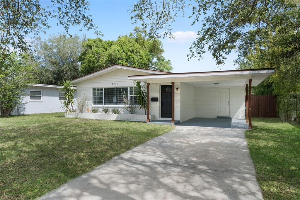 A single-story house with a white brick exterior, a front carport, and a concrete driveway — 1741 WESTCHESTER AVENUE, WINTER PARK, FL