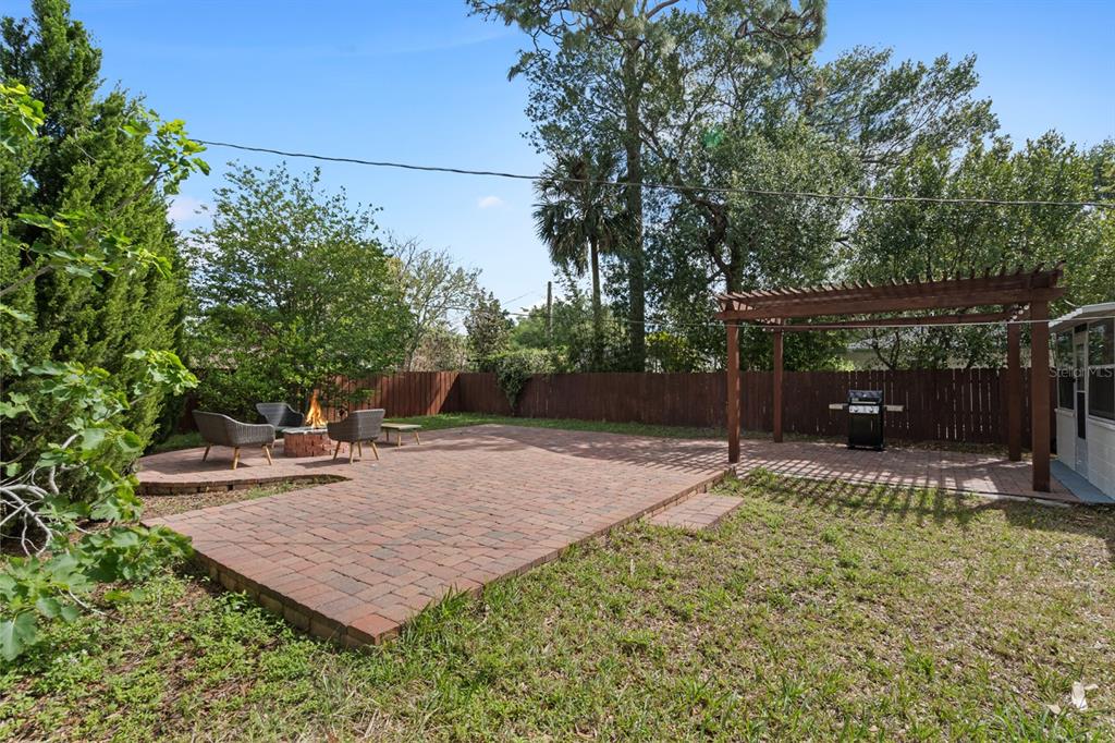A backyard features a brick paver patio with a fire pit and a wooden pergola — 1741 WESTCHESTER AVENUE, WINTER PARK, FL