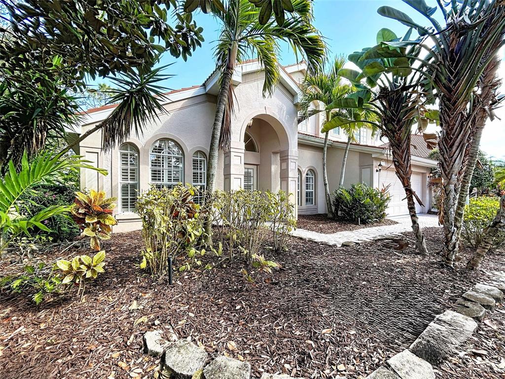A single-story stucco house with arched windows and a palm-lined front yard — 7703 BRITISH OPEN WAY, LAKEWOOD RANCH, FL