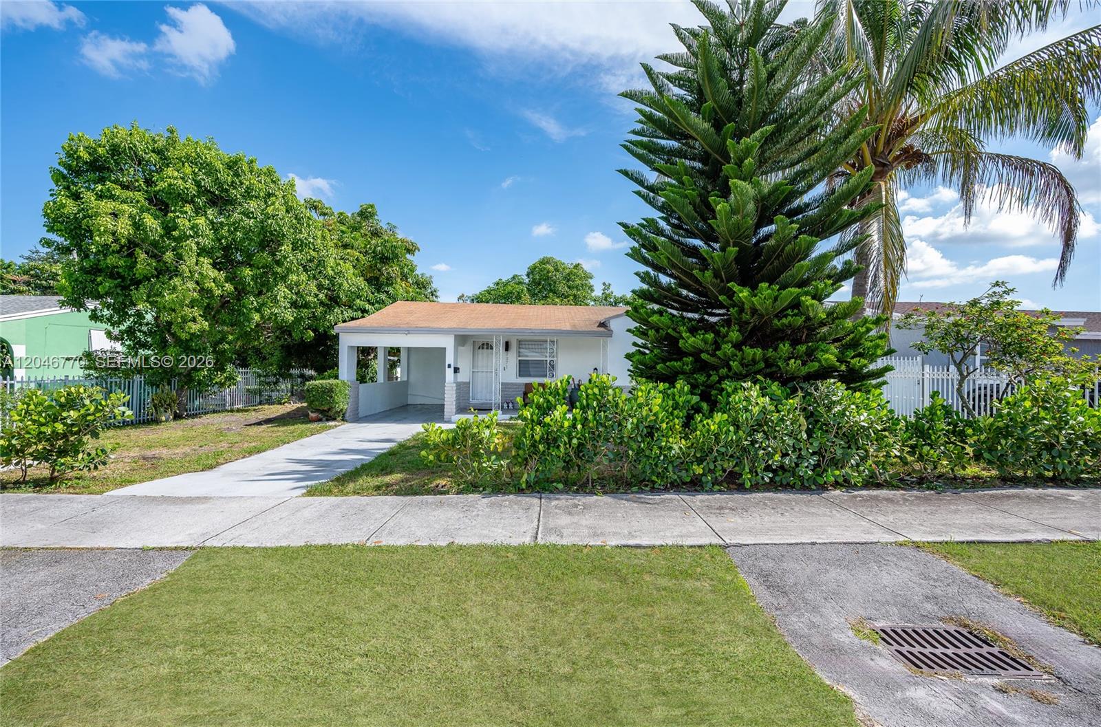 A single-story house with a carport, a large pine tree, and a front lawn — 2371 NW 85th St, Miami FL 33147, MIAMI, FL