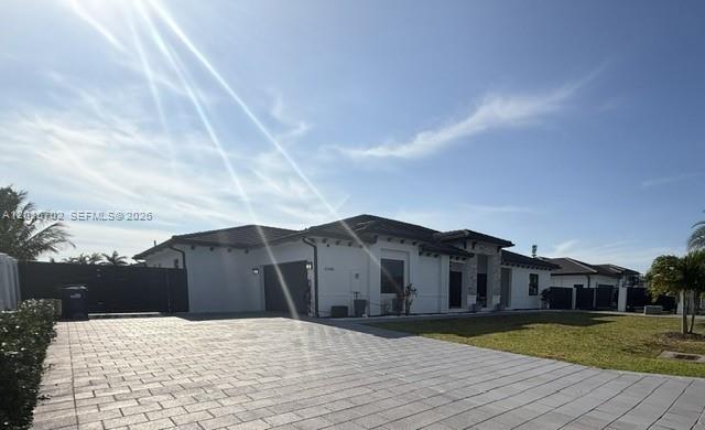 A single-story white house with a paved driveway and a dark tile roof — 21480 SW 132nd Ct, Miami FL 33177, MIAMI, FL