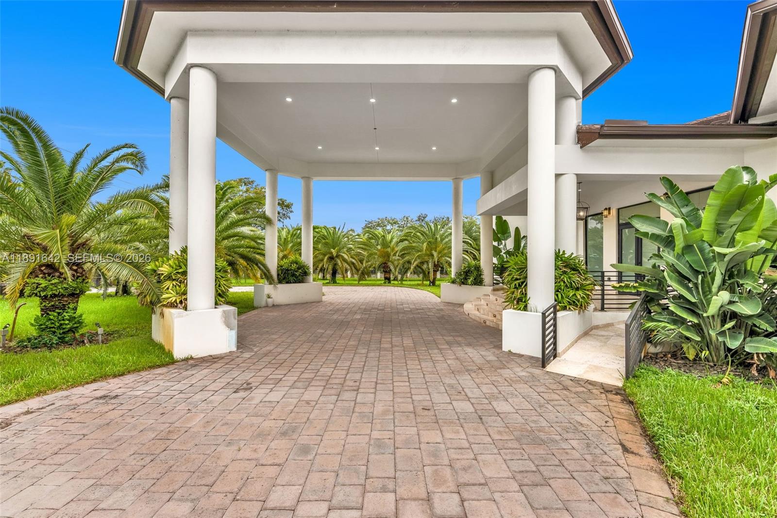 A paved driveway leads to a covered porte-cochère entrance supported by white columns — 12175 SW 45th St, Miami FL 33175, MIAMI, FL