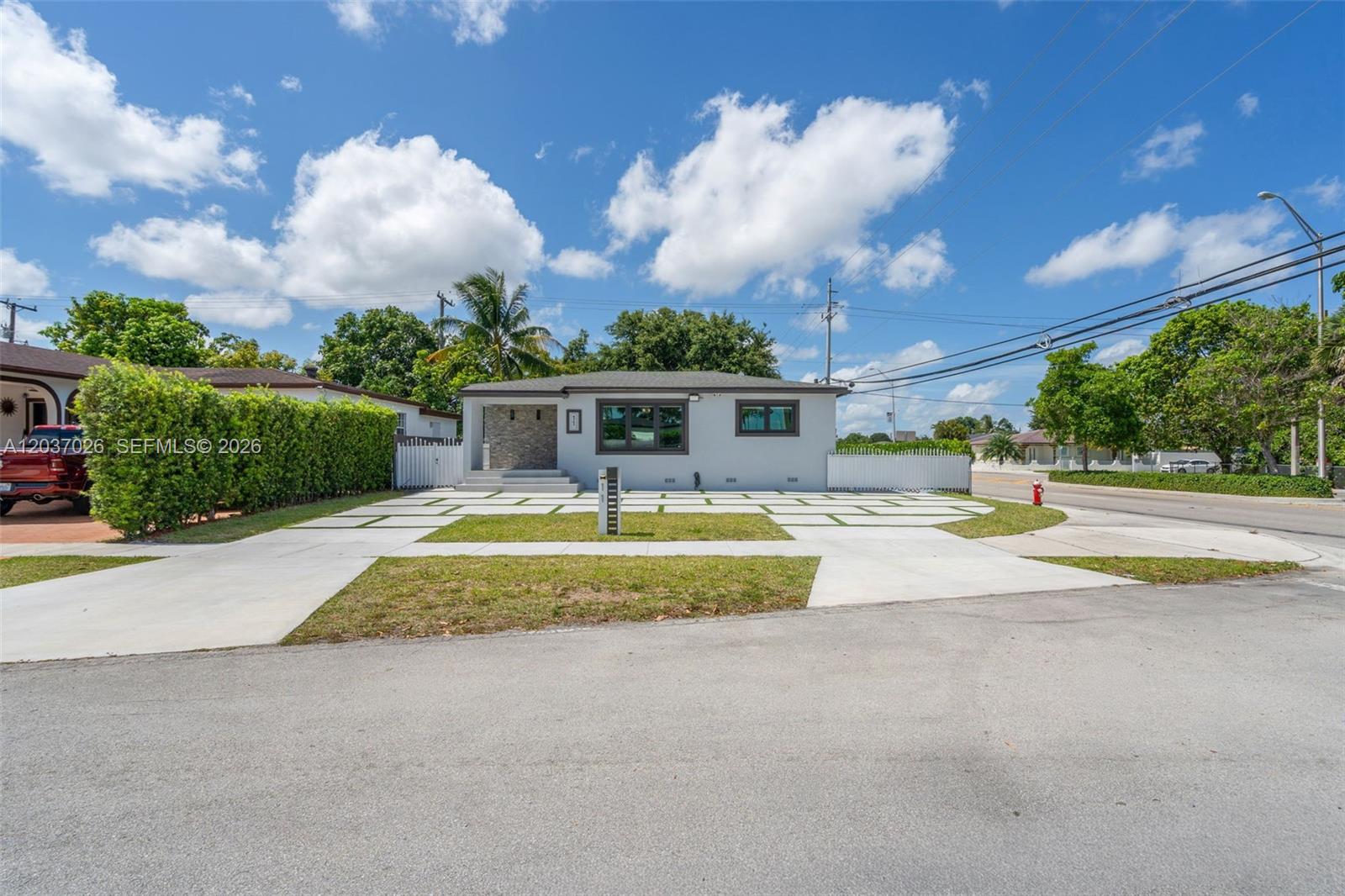 A single-story house with a gray exterior, stone accent wall, and a concrete paver driveway — 11 W 59th St, Hialeah FL 33012, HIALEAH, FL