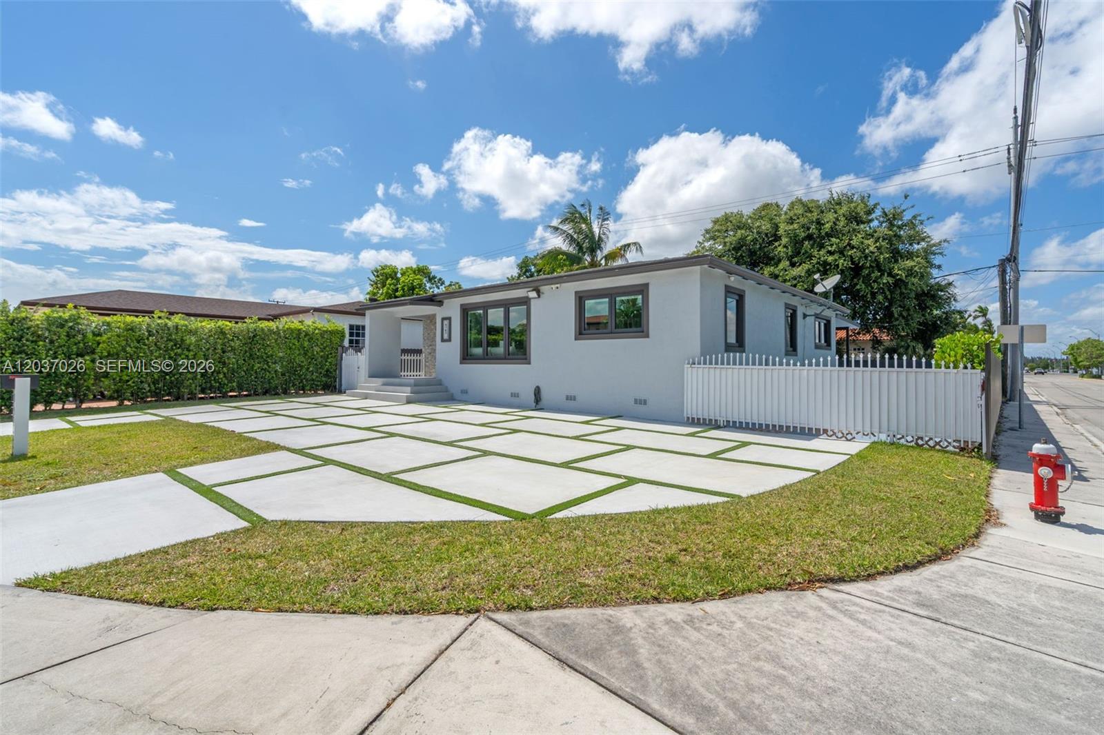 A single-story house features a light gray exterior, dark window frames, and a paved driveway — 11 W 59th St, Hialeah FL 33012, HIALEAH, FL