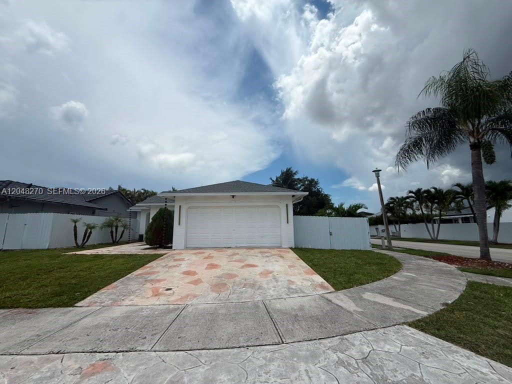 A white single-story house with a stone driveway and a palm tree in the yard — 14305 SW 182nd Ter # 0, Miami FL 33177, MIAMI, FL