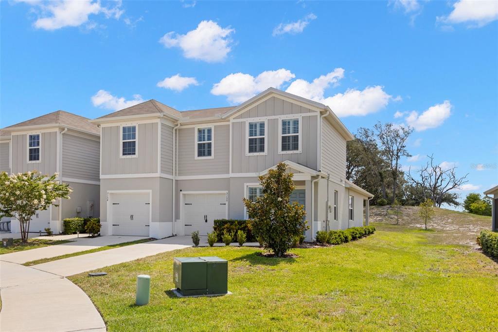 A two-story townhouse with a light gray exterior, two garages, and a grassy front yard — 3150 VICTORIA INLET DRIVE, HOLIDAY, FL