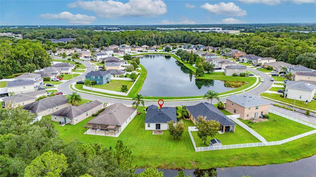 An aerial view shows a residential neighborhood with houses surrounding a central lake — 2637 WALDEN WOODS DRIVE, PLANT CITY, FL