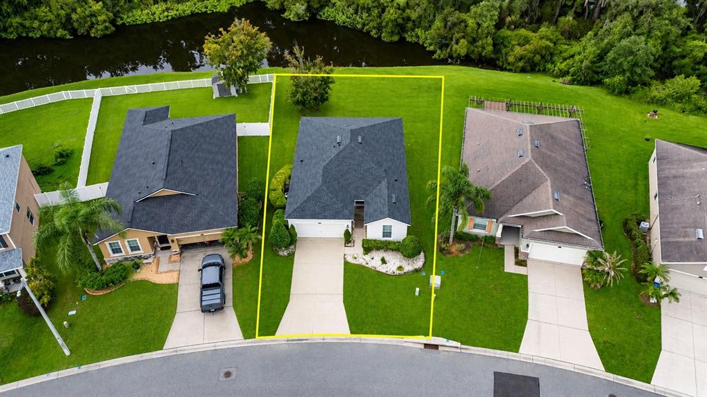 An aerial view shows a residential house with a dark roof and a concrete driveway — 2637 WALDEN WOODS DRIVE, PLANT CITY, FL
