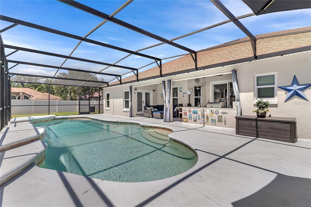 A kitchen features white cabinets, stainless steel appliances, dark countertops, and wood-look flooring — 3245 COUNTRYSIDE VIEW DRIVE, ST CLOUD, FL
