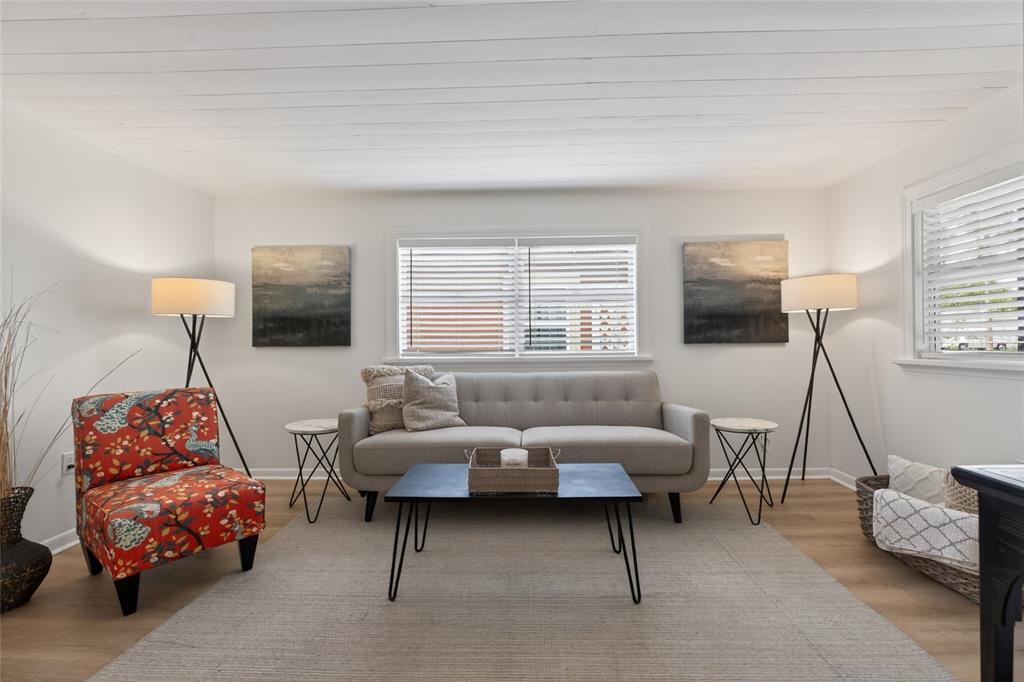 A living room features a gray sofa, a patterned armchair, and two tripod floor lamps — 5617 19TH AVENUE S, ST PETERSBURG, FL