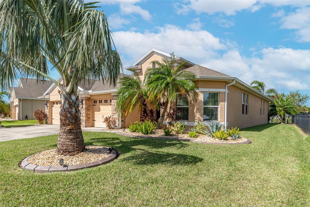 A tan single-story house with a palm tree in the front yard and a driveway — 11236 77TH STREET E, PARRISH, FL