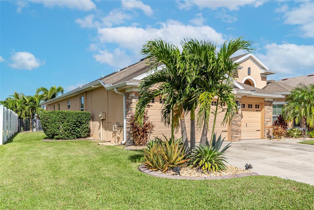 A tan house with a stone-accented garage and a palm tree in the front yard — 11236 77TH STREET E, PARRISH, FL