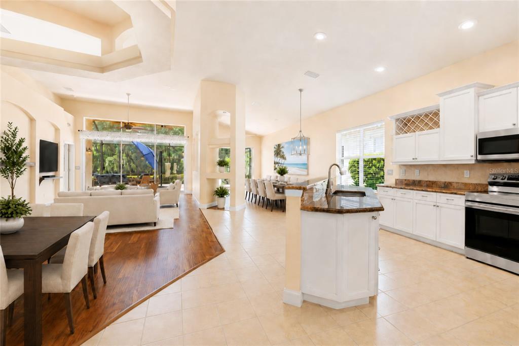 An open-concept kitchen and living area with tile floors, white cabinetry, and a dining space — 3 VILLAGE VIEW DRIVE, PALM COAST, FL