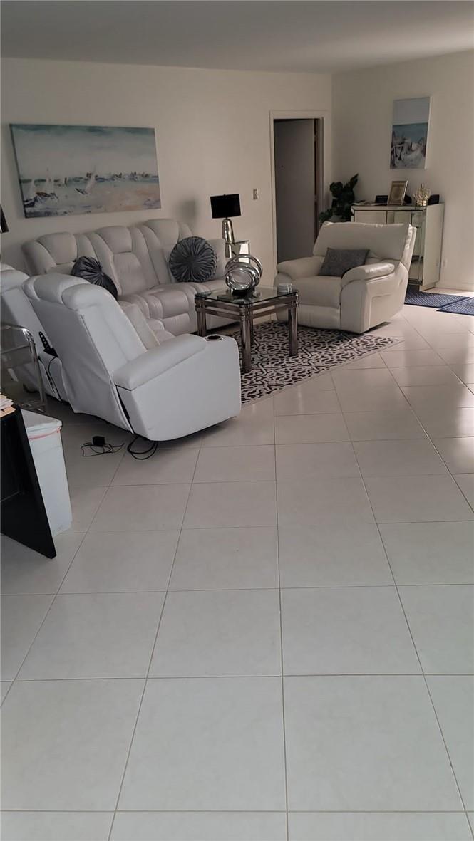 A living room features white leather furniture, a glass coffee table, and tiled flooring — 6574 Burning Wood Drive # 101, Boca Raton FL 33433, BOCA RATON, FL
