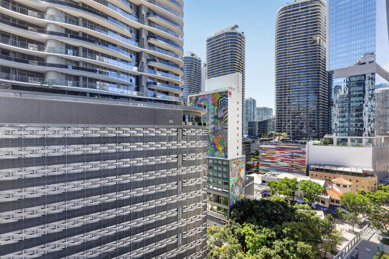 An exterior view of a modern urban skyline featuring high-rise buildings and a colorful mural — 1010 Brickell Avenue # 1607, Miami FL 33131, MIAMI, FL