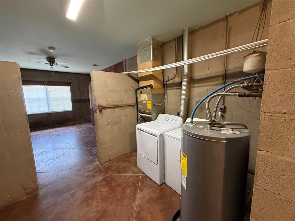 A utility room features a water heater, washer, dryer, and HVAC unit on concrete floors — 2308 FERN PALM DRIVE, EDGEWATER, FL