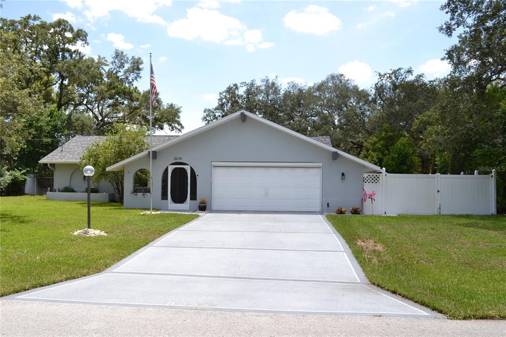 A single-story house with a gray exterior, a two-car garage, and a concrete driveway — 8236 ANNAPOLIS ROAD, SPRING HILL, FL
