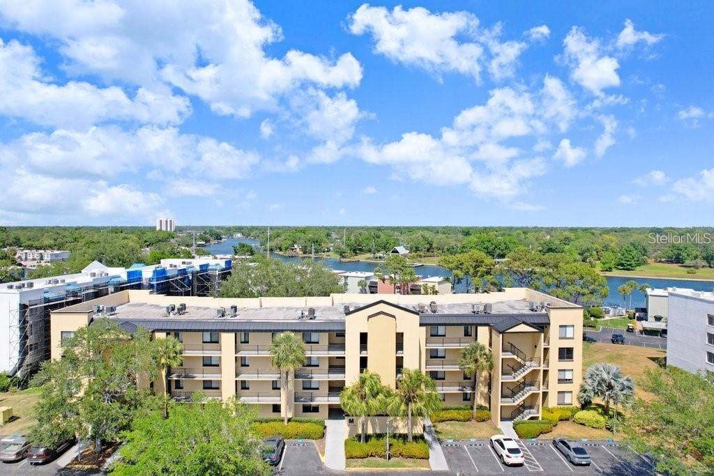 An aerial view of a multi-story apartment building with a parking lot and waterfront — 2424 W TAMPA BAY BOULEVARD UNIT M205, TAMPA, FL