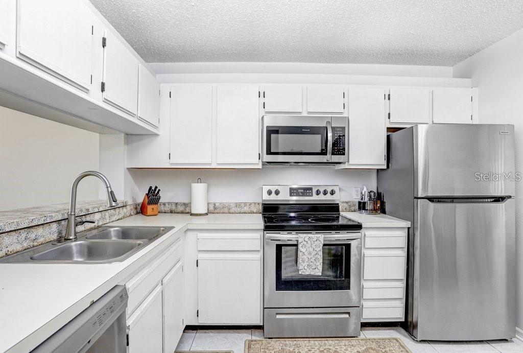 A kitchen with white cabinets, stainless steel appliances, and granite countertops — 2424 W TAMPA BAY BOULEVARD UNIT M205, TAMPA, FL