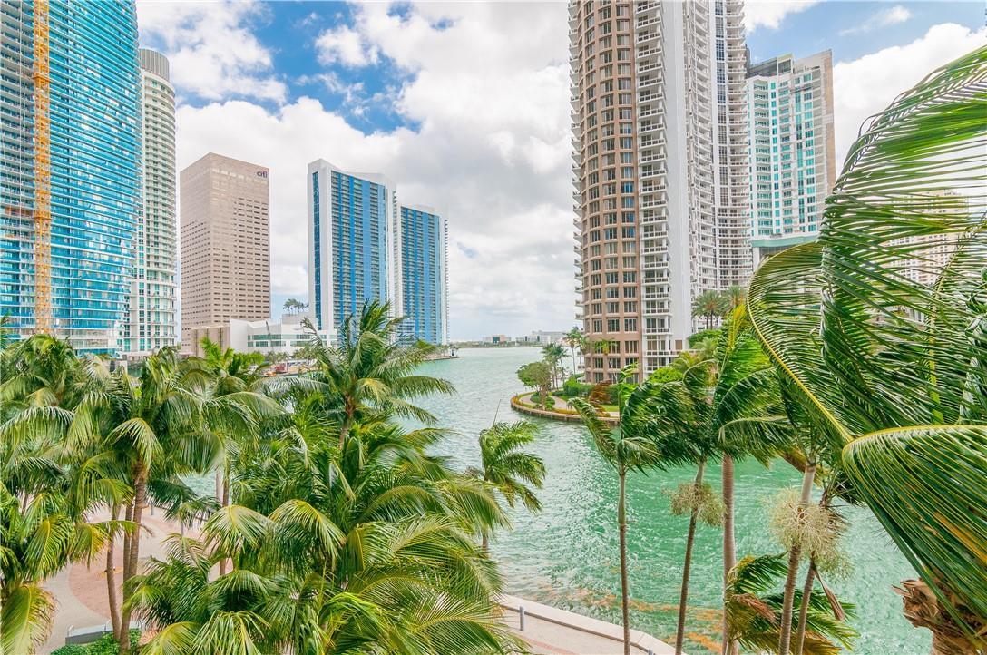 A view of a waterfront canal surrounded by tall skyscrapers and lush palm trees — 465 Brickell Avenue # 419, Miami FL 33131, MIAMI, FL