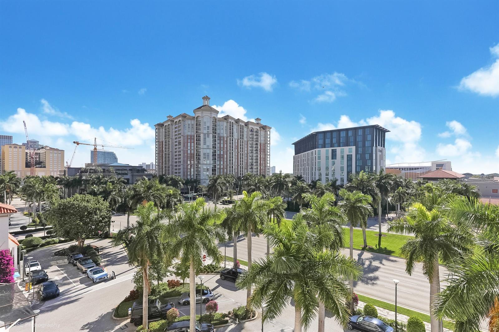 An elevated view shows a street with palm trees, parking lots, and modern high-rise buildings — 651 Okeechobee Boulevard # 509, West Palm Beach FL 33401, WEST PALM BEACH, FL