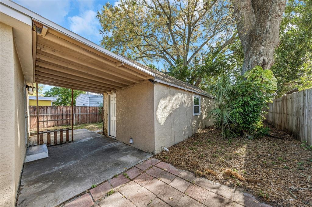 A concrete patio area features a covered carport attached to the side of a house — 4139 26TH STREET N, ST PETERSBURG, FL