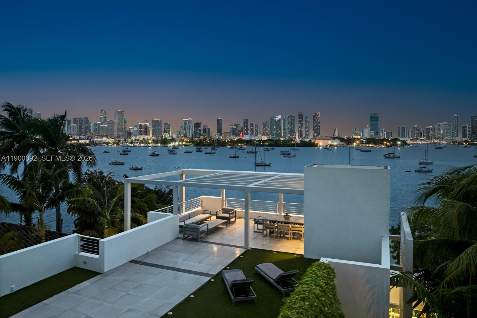 An elevated outdoor terrace features a covered dining area, lounge seating, and a city skyline view — 440 S Hibiscus Dr, Miami Beach FL 33139, MIAMI BEACH, FL