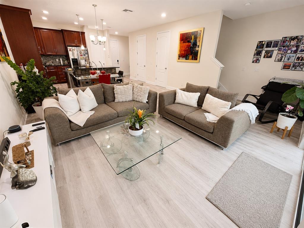 A living room features two gray sofas, a glass coffee table, and light wood flooring — 14164 SWANLEY STREET, ORLANDO, FL
