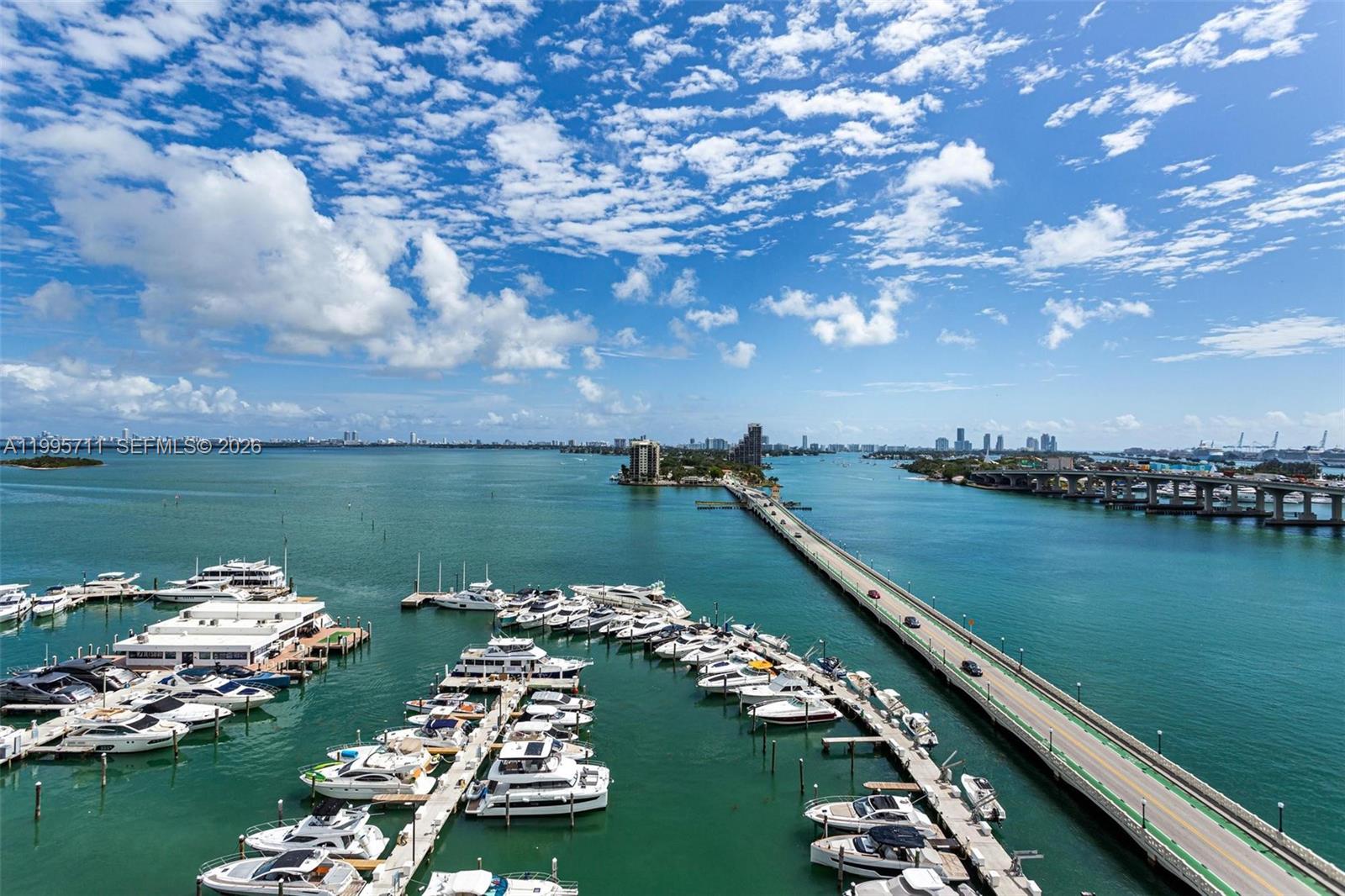 An elevated view of a marina with numerous yachts docked beside a long bridge — 555 NE 15th St # 15B, Miami FL 33132, MIAMI, FL