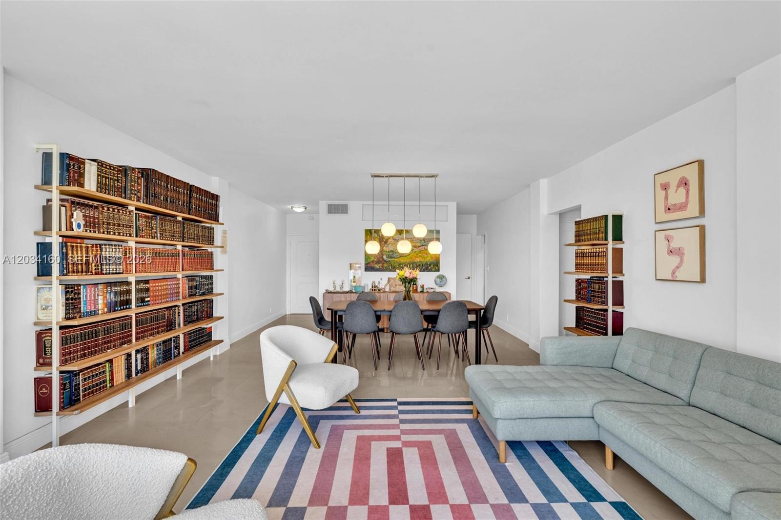 A living and dining area features a large bookshelf, a sectional sofa, and a rug — 9381 E Bay Harbor Dr # 202s, Bay Harbor Islands FL 33154, BAY HARBOR ISLANDS, FL