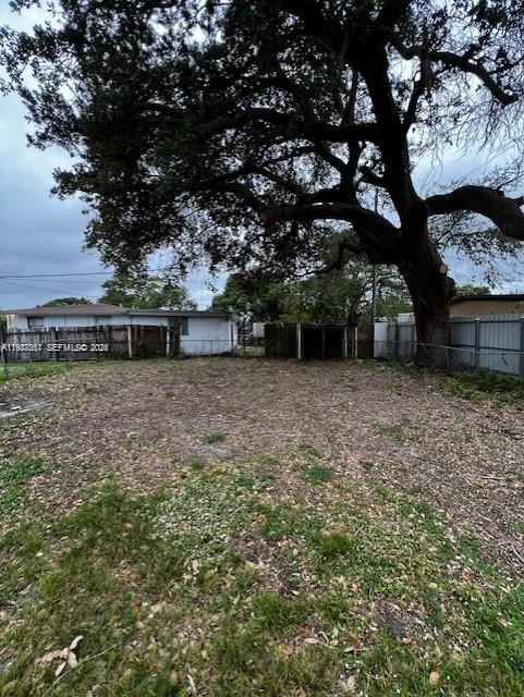 A large, mature tree stands over a vacant, grassy lot behind a wooden fence — 3811 SW 31st Ct, West Park FL 33023, WEST PARK, FL
