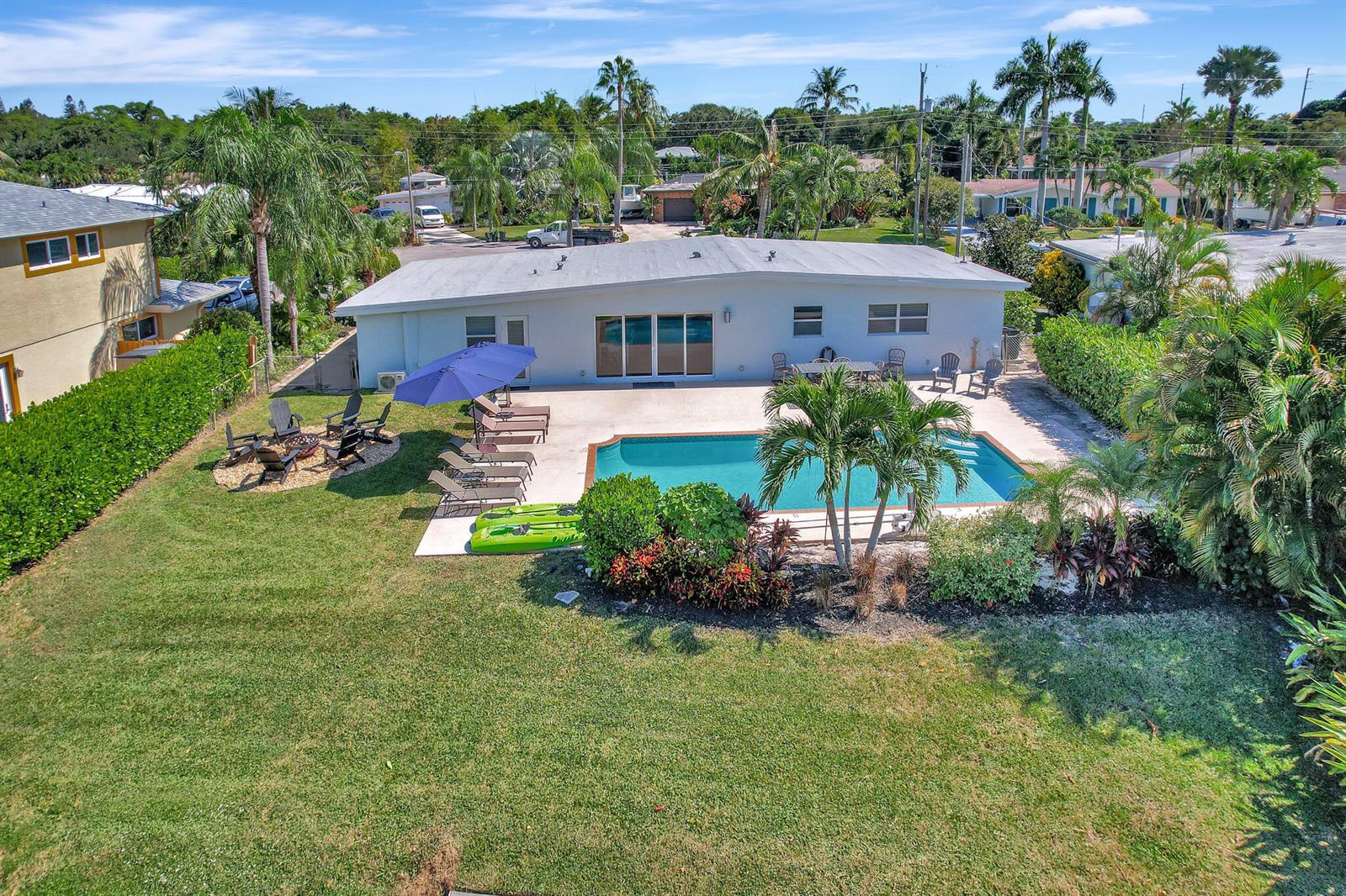 An aerial view of a backyard featuring a swimming pool, patio, and green lawn — 6821 Kingston Drive, Lake Worth FL 33462, LAKE WORTH, FL