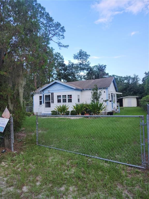 A white house with blue trim and a chain-link fence in the front yard — 1427 SE 1ST AVENUE, GAINESVILLE, FL