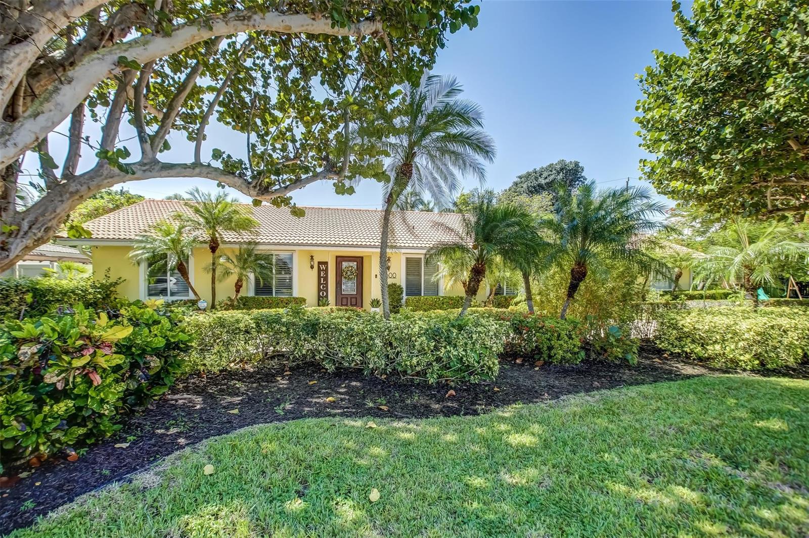 A yellow single-story house with a tiled roof, palm trees, and landscaped front yard — 2600 N Riverside Drive, Pompano Beach FL 33062, POMPANO BEACH, FL