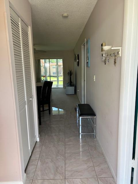 A tiled hallway leads to a living area with a sliding glass door and carpet — 1903 SW Palm City Road # 2, Stuart FL 34994, STUART, FL