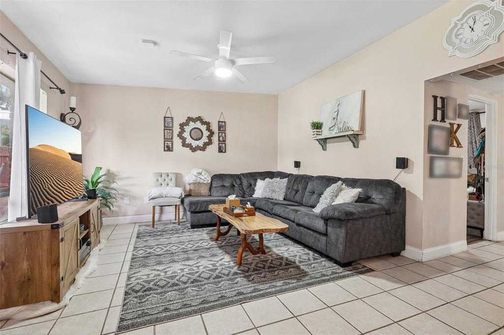 A living room features a gray sectional sofa, a wooden coffee table, and a television — 4301 MIZELL STREET, ORLANDO, FL