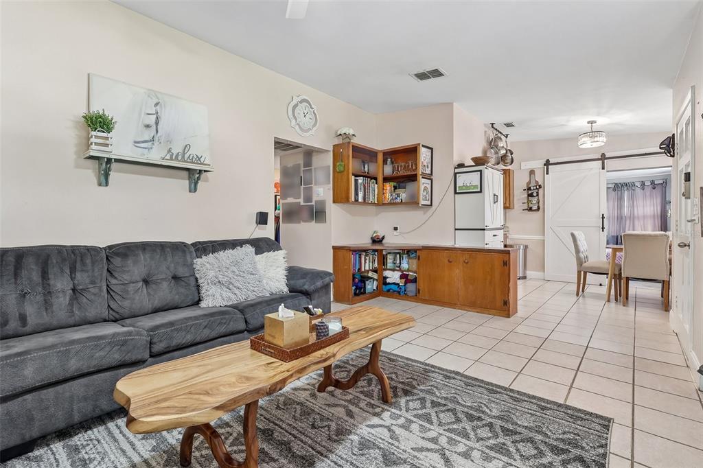 A living room features a gray sofa, a live-edge coffee table, and built-in wooden cabinetry — 4301 MIZELL STREET, ORLANDO, FL