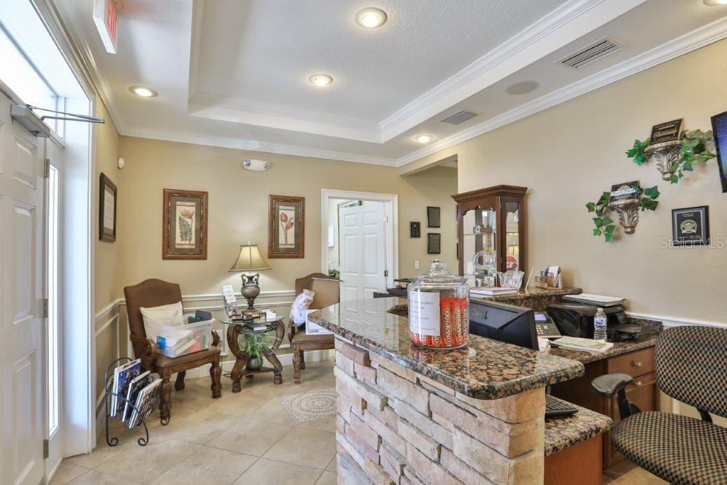 A reception area features a stone-front desk, granite countertops, tile flooring, and two armchairs — 437 APOLLO BEACH BOULEVARD UNIT F-4, APOLLO BEACH, FL