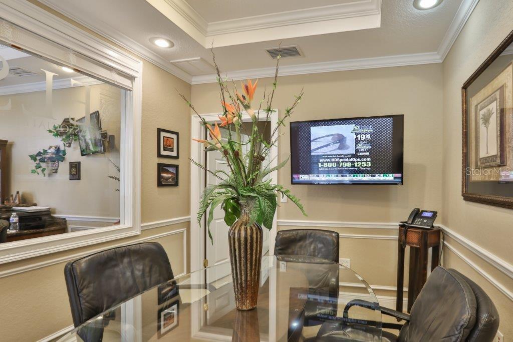 A small office with a glass table, leather chairs, a wall-mounted television, and a mirror — 437 APOLLO BEACH BOULEVARD UNIT F-4, APOLLO BEACH, FL