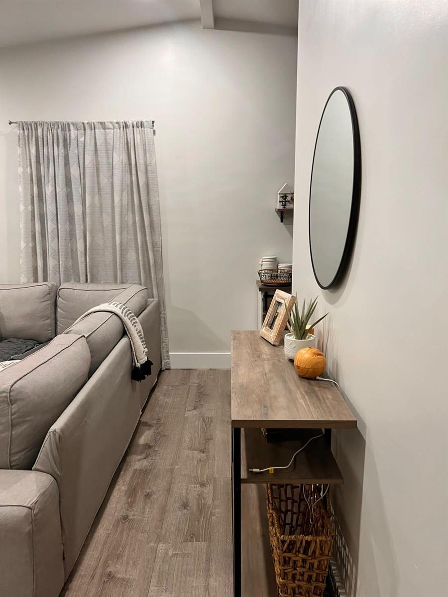 A narrow hallway features a console table, a round wall mirror, and a gray sofa — 555 NW 15th Court, Pompano Beach FL 33060, POMPANO BEACH, FL