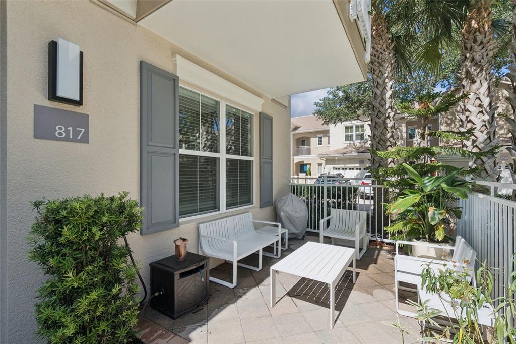 A patio features white metal furniture, a small table, and a grill on a tiled floor — 817 GREYBULL RUN, LAKE MARY, FL