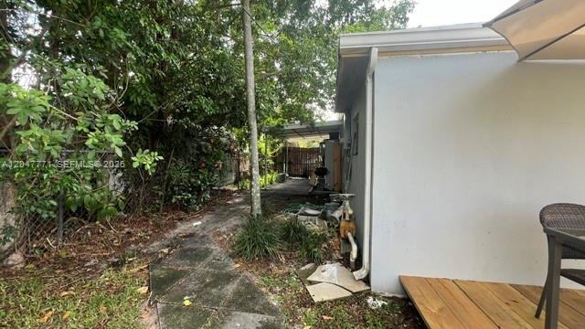 A narrow concrete path leads along the side of a house toward a backyard structure — 3000 N 72nd Way, Hollywood FL 33024, HOLLYWOOD, FL