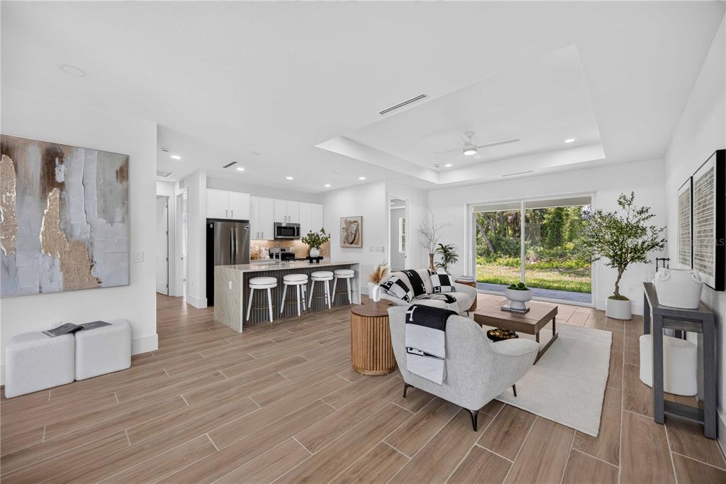 An open-concept kitchen and living area features white cabinetry, a stone island, and tile flooring — 16213 CASHMERE AVENUE, PORT CHARLOTTE, FL
