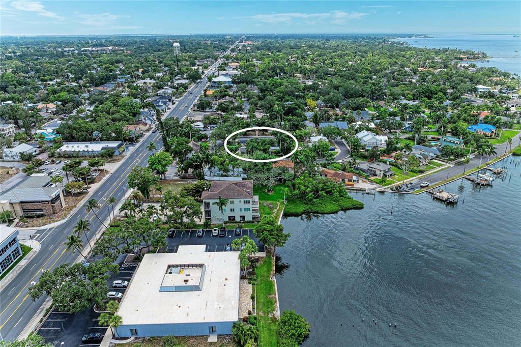 An aerial view shows a coastal neighborhood with a white-circled property near the water — 405 20TH STREET W, BRADENTON, FL