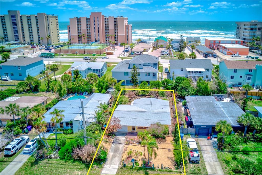 An aerial view shows a single-story house outlined in yellow near a beach — 3841 CARDINAL BOULEVARD, PORT ORANGE, FL