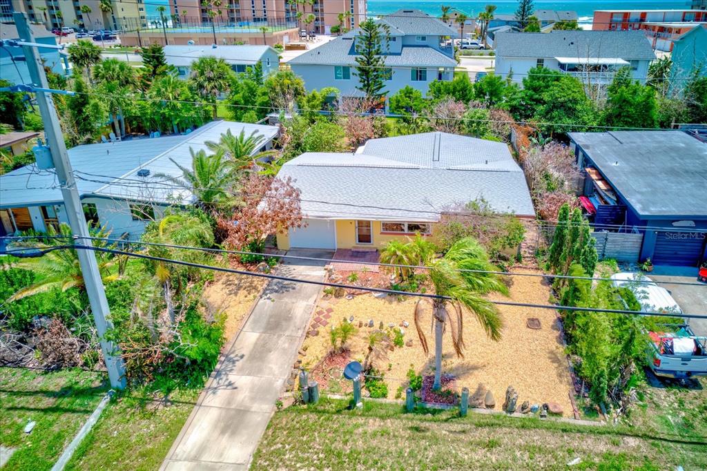 An aerial view shows a single-story house with a light-colored roof and a gravel yard — 3841 CARDINAL BOULEVARD, PORT ORANGE, FL