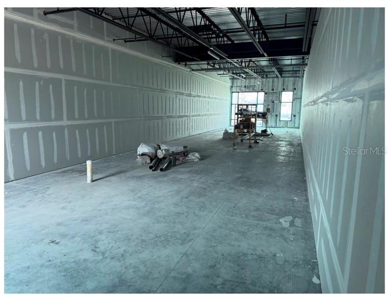 An unfinished commercial space features bare concrete floors and walls with exposed drywall seams — 6355 INITIATIVE BOULEVARD UNIT 110, SARASOTA, FL