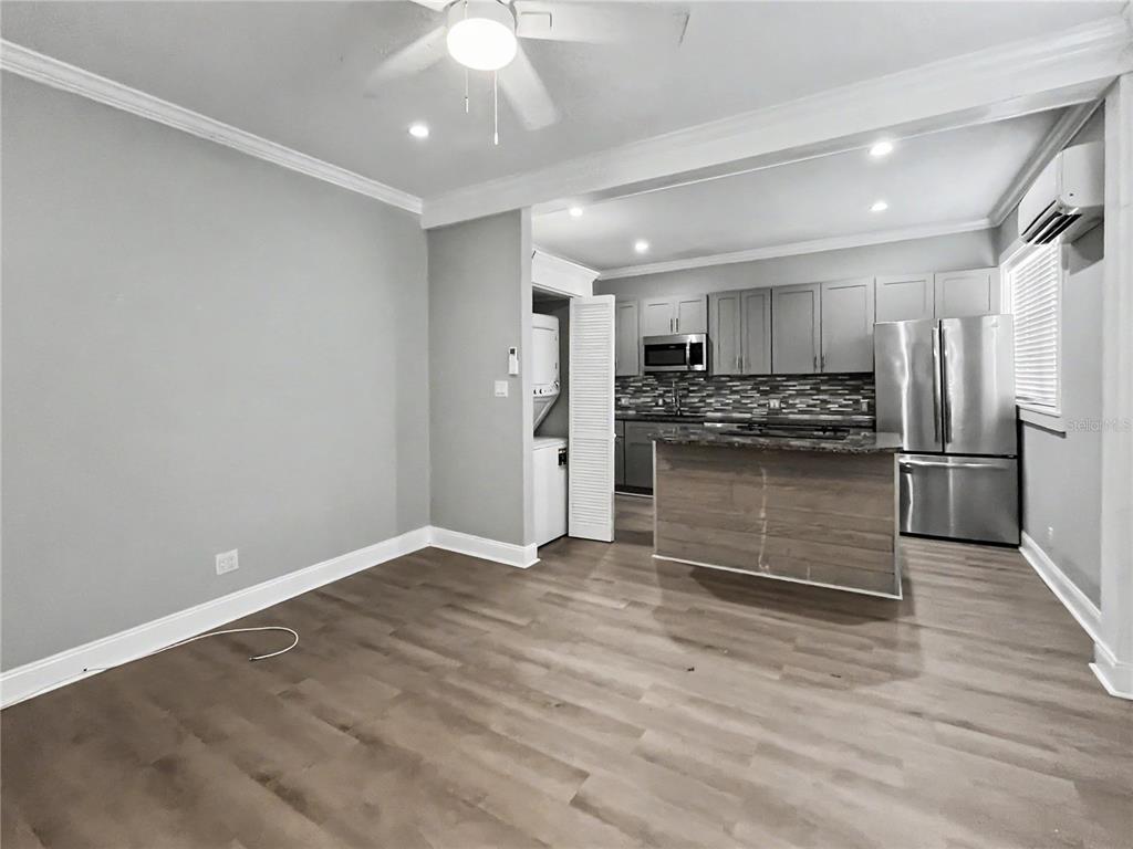 A kitchen with stainless steel appliances and a wooden island opens into a gray living area — 408 ARMADA ROAD S UNIT 2, VENICE, FL