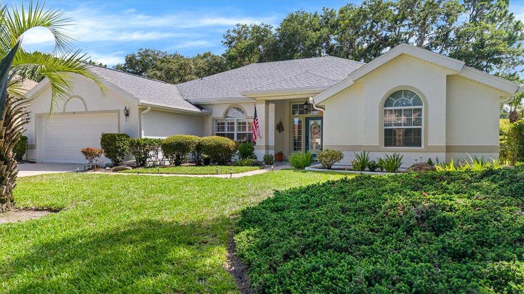 A single-story house with a white stucco exterior, a two-car garage, and a landscaped yard — 52 SOUTHLAKE DRIVE, PALM COAST, FL
